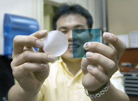 Ho Bum Park holding two samples of the chlorine-tolerant, desalination membrane