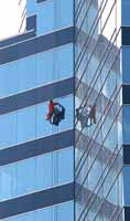 Window cleaner hanging from skyscraper