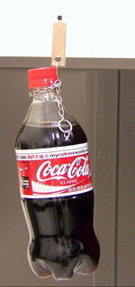 A bottle of cola suspended from a glass surface using the nanotube glue