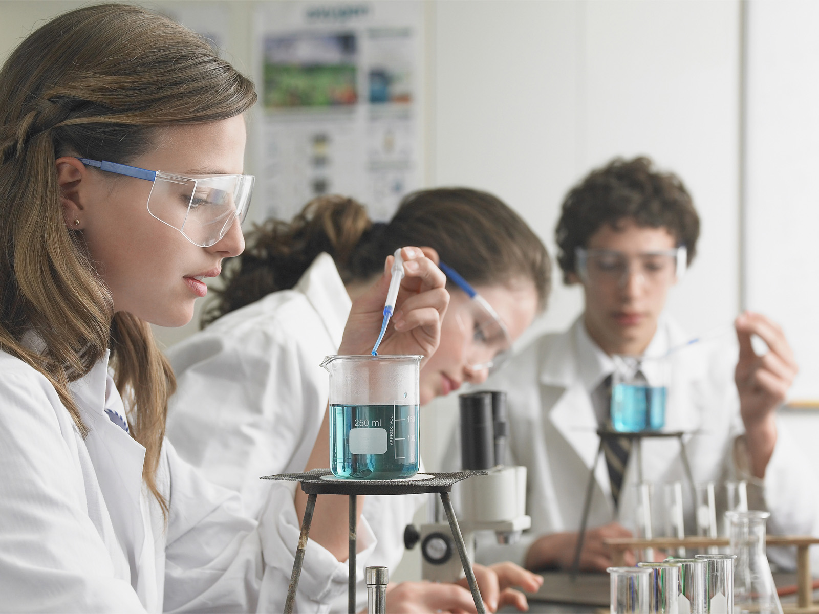 Teenage students doing simple chemistry experiments in a teaching lab. Teenage students doing simple chemistry experiments in a teaching lab.