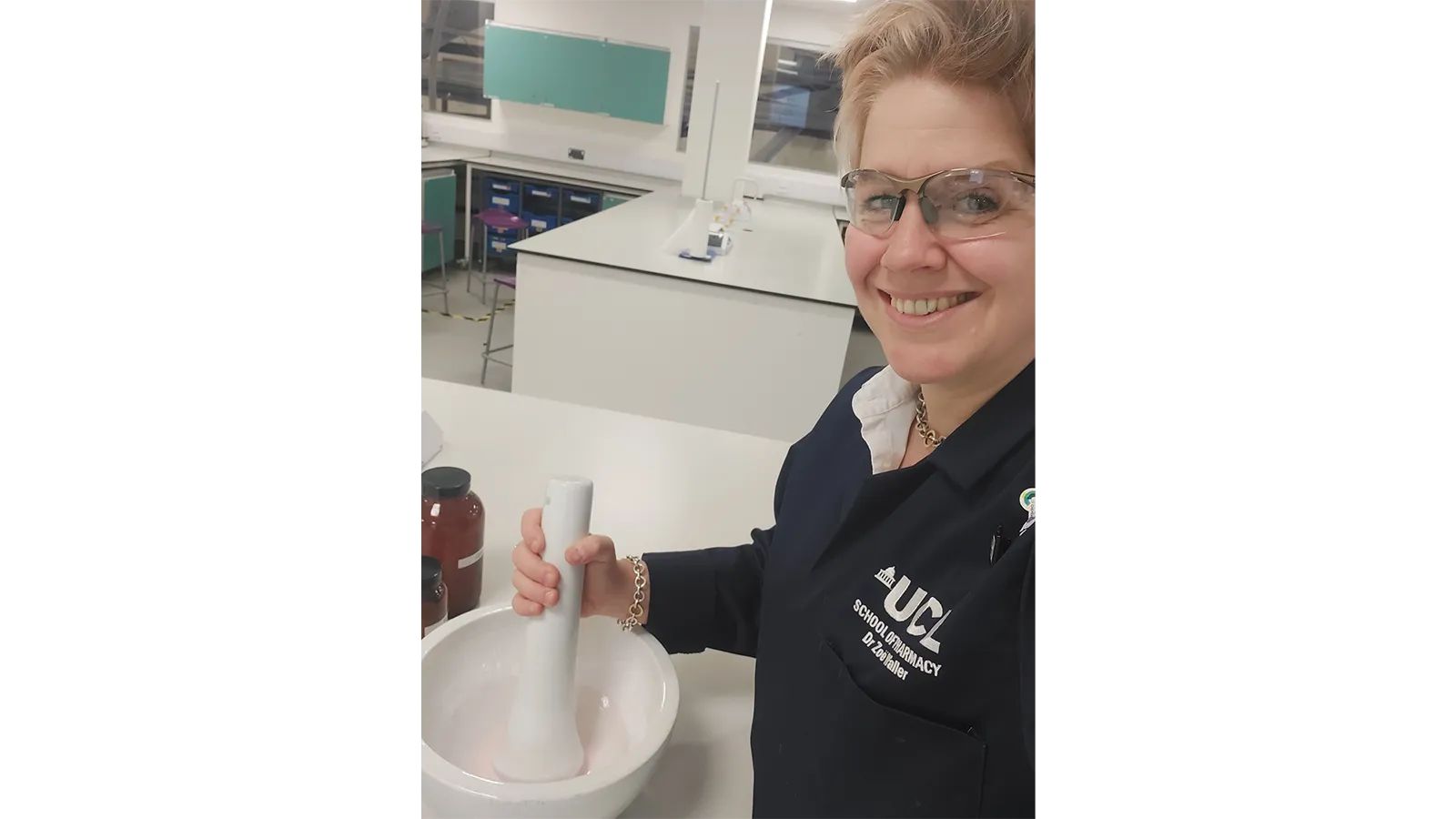 Zoe wearing glasses, with large pestle and mortar and UCL navy sweatshirt on