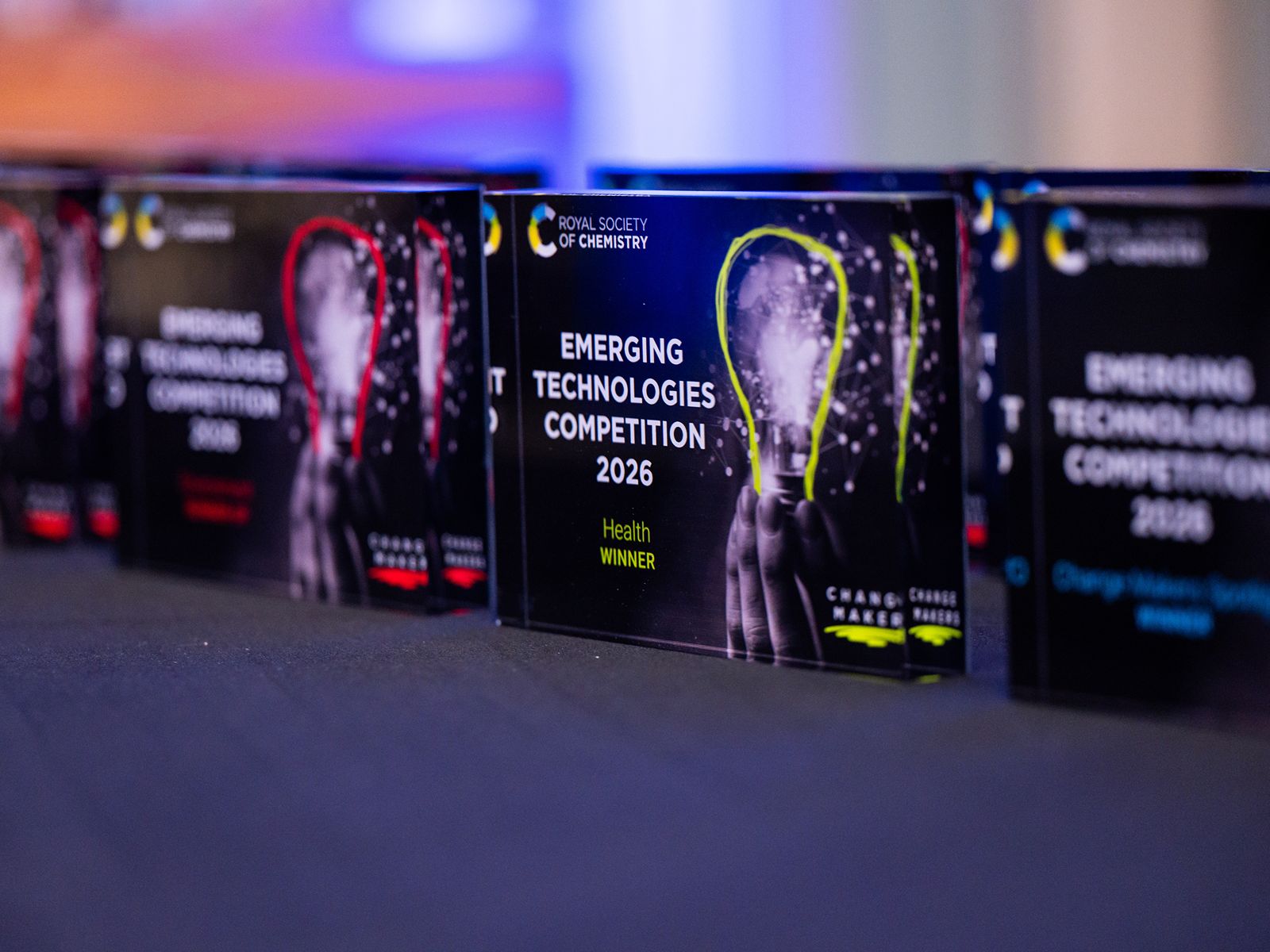 Emerging Technologies Competition 2026 (4) (1) A series of four plaques sat on a table with imagery on each that reads "Emerging Technologies Competition 2026"