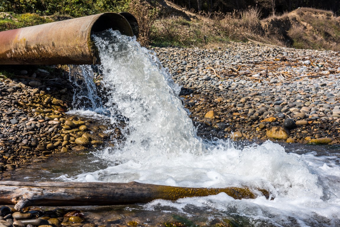 A sewage pipe pumps water into the environment A sewage pipe pumps water into the environment