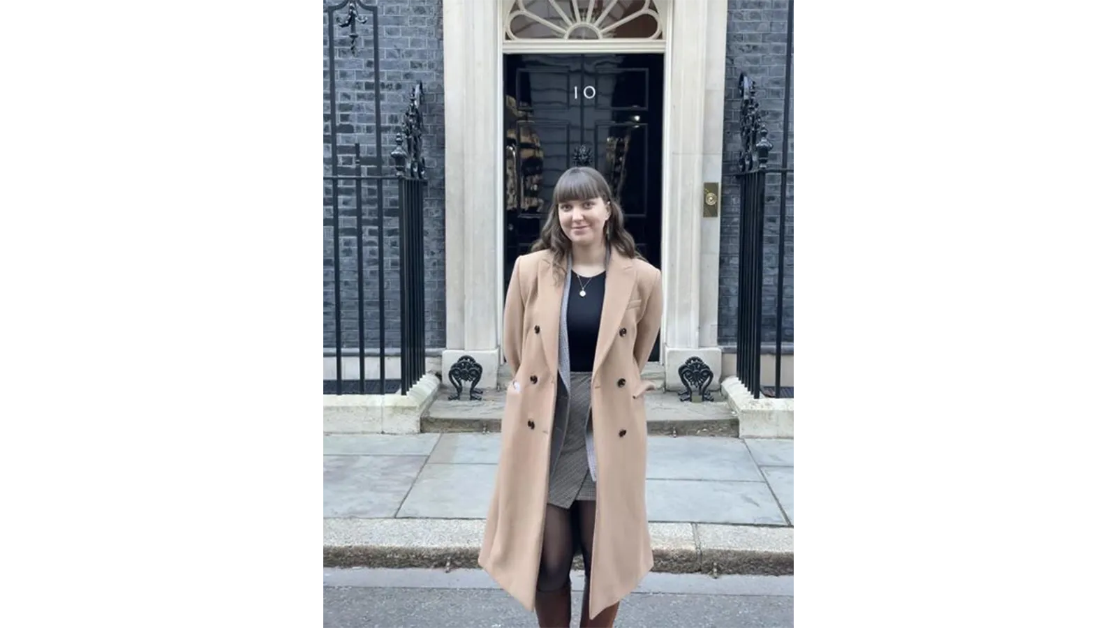 Mia Outram in a smart outfit standing in front of 10 Downing Street, London