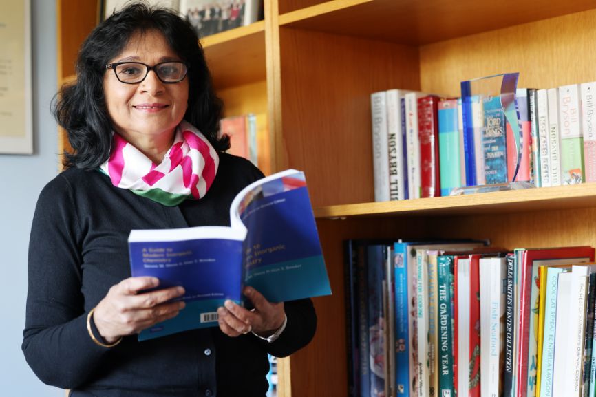 Professor Anju Massey-Brooker, industry associate at the Royal Society of Chemistry, smiles at the camera while holding a book open while stood in front of a bookcase Professor Anju Massey-Brooker, industry associate at the Royal Society of Chemistry, smiles at the camera while holding a book open while stood in front of a bookcase