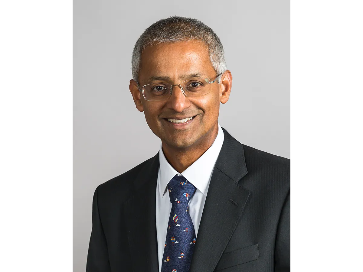 Professor Sir Shankar Balasubramanian smiling with glasses,suit and tie
