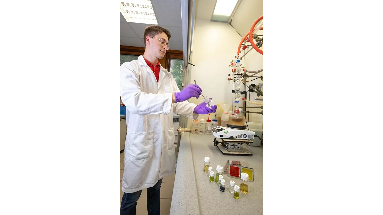 PISCO Team member in a lab coat and gloves with specimens in vials