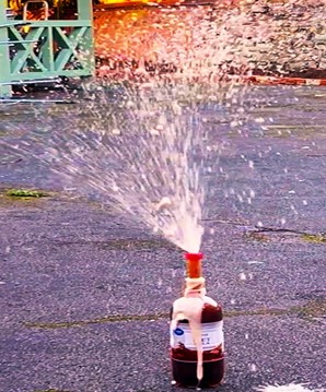 A bottle of Coca-Cola splutters all over a car park after some Menthos were dropped in the top A bottle of Coca-Cola splutters all over a car park after some Menthos were dropped in the top