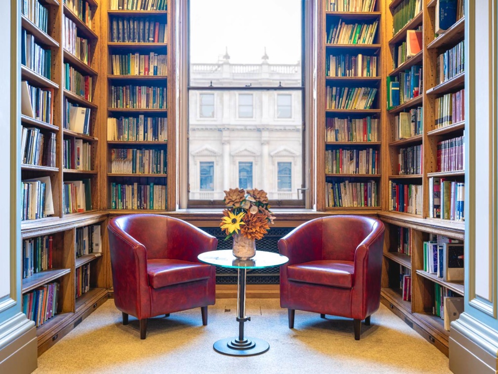 two-chairs-in-library-against-window-and-bookshelf-backdrop