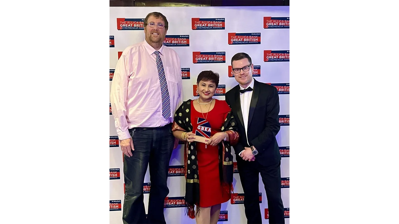 Professor Damion Corrigan with others and with a prize trophy at an event