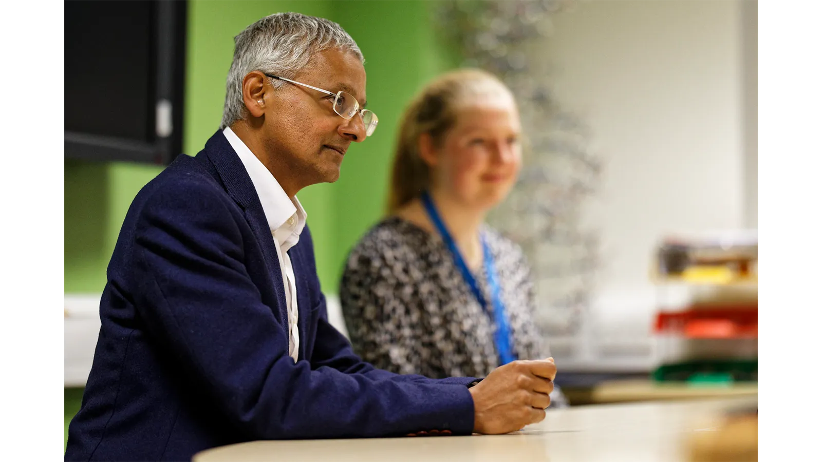 Professor Sir Shankar Balasubramanian at a table at meeting with others