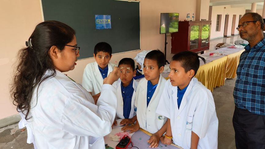 A scientist shows something to four young students at the special event A scientist shows something to four young students at the special event
