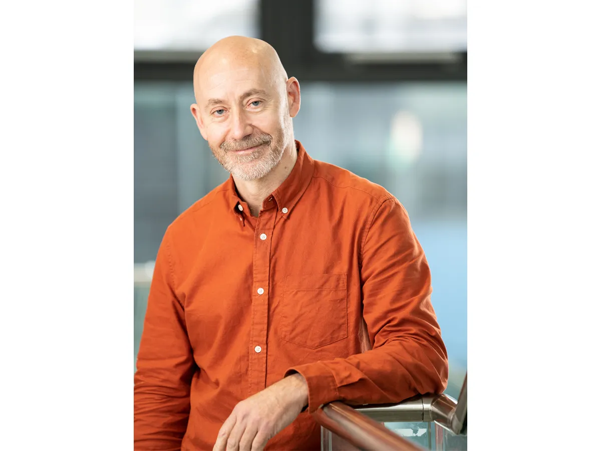 Professor Cameron Alexander in an orange shirt