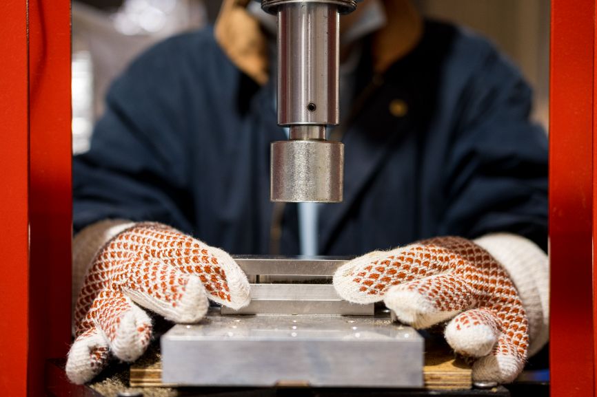 A pair of gloved hands works on a machine to produce Notpla Rigid A pair of gloved hands works on a machine to produce Notpla Rigid