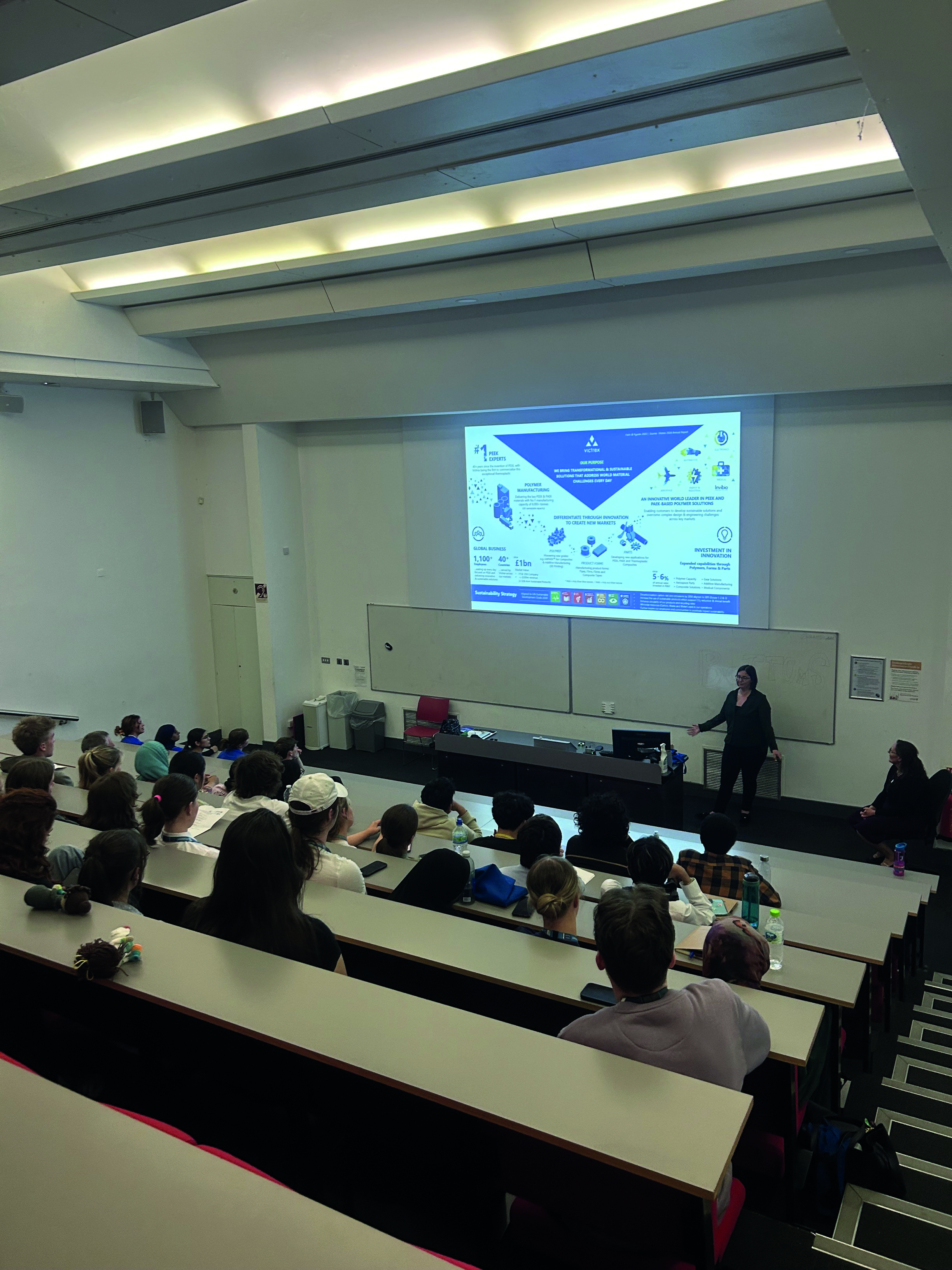 Community news - Lancaster University programme (9) A speaker stands at the front of a lecture theatre and talks to the students