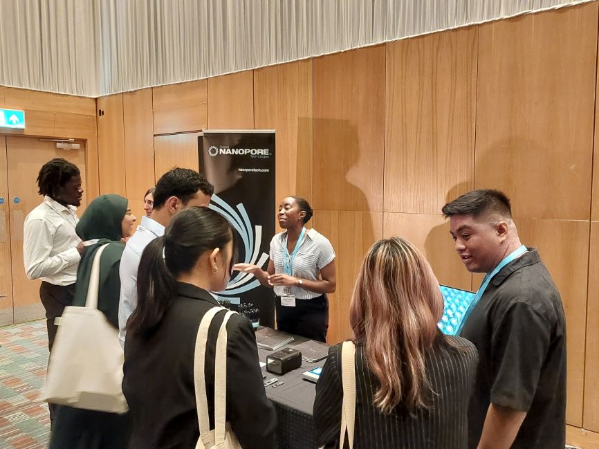 Students speak with representatives from Oxford Nanopore in front of a Oxford Nanopore hanging banner Students speak with representatives from Oxford Nanopore in front of a Oxford Nanopore hanging banner