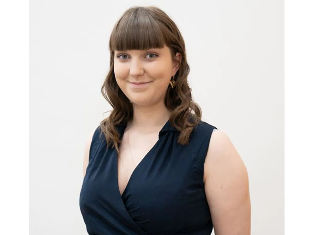 Mia Outram in a black dress smiling for the camera