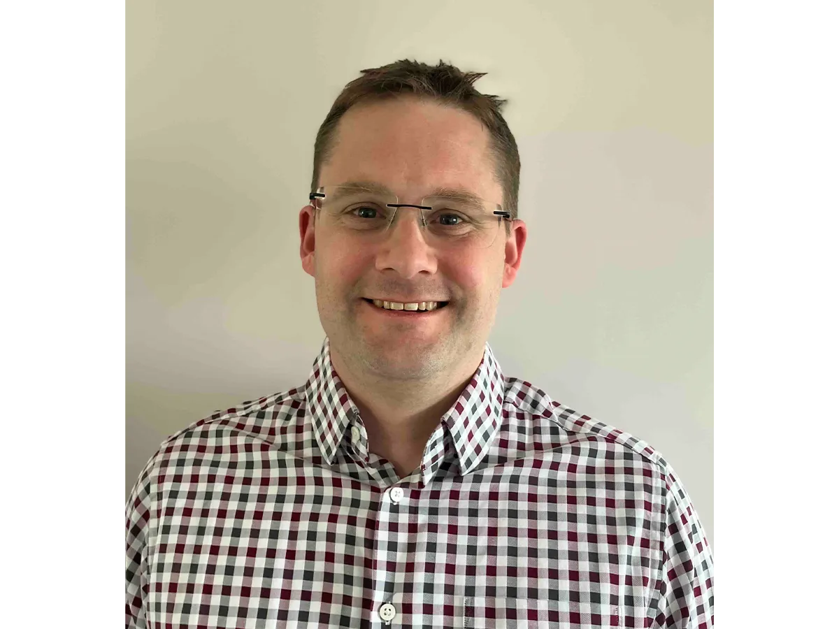 Professor Thomas Penfold wearing glasses and a checked shirt