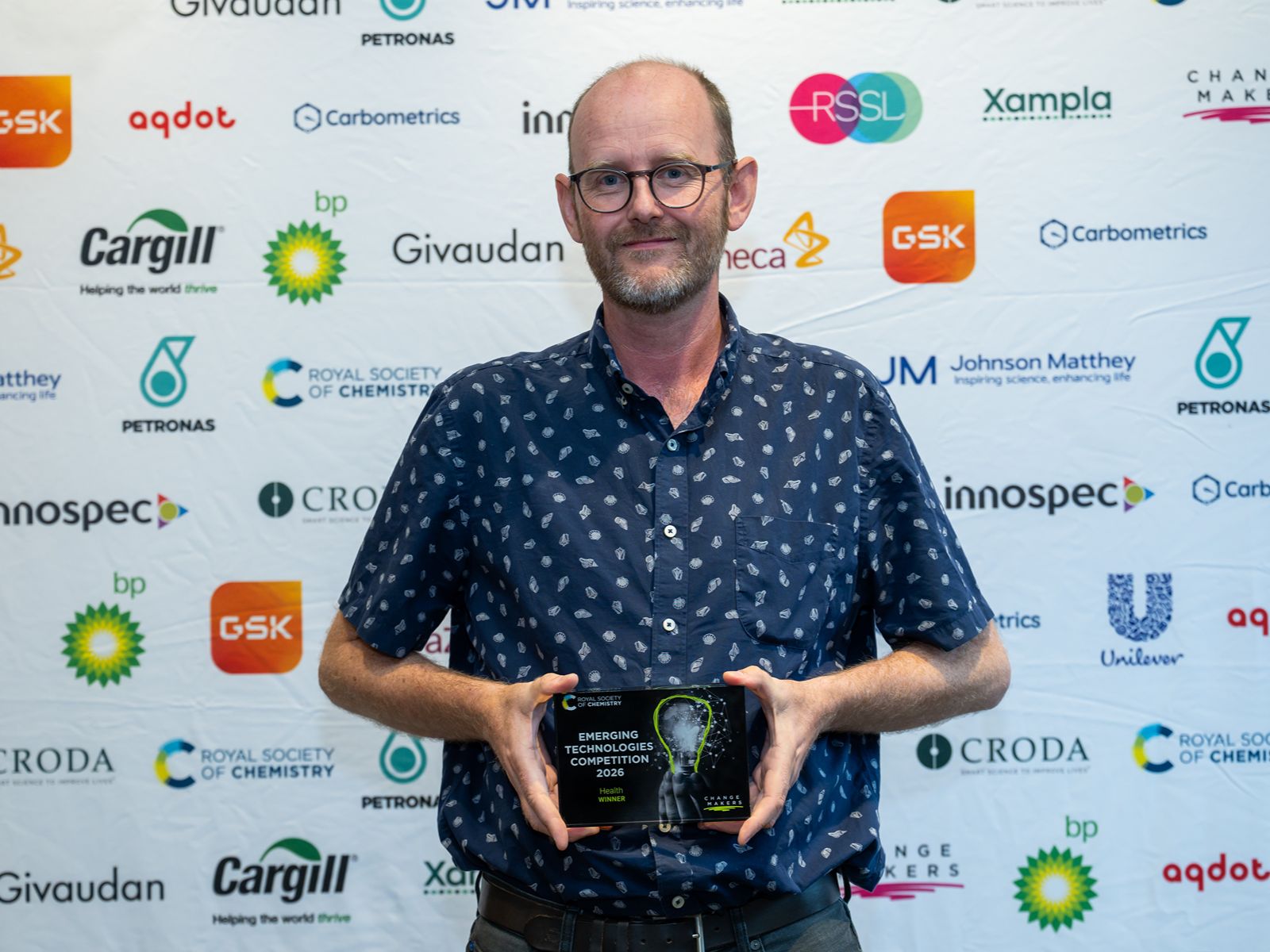 Emerging Technologies Competition - Jody (1) Jody Mason, chief science officer and founder of Revolver Therapeutics, smiles and holds an award