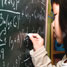 Chinese girl writing complex formula on blackboard